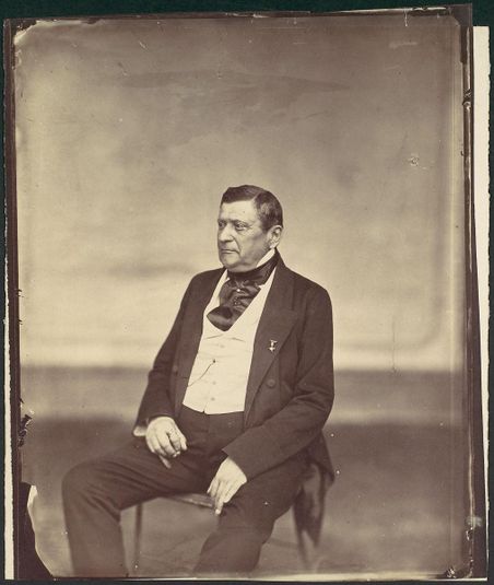 [Seated Man in White Vest and Dark Coat]