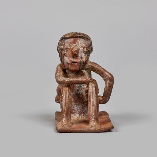 Figure seated on a stool