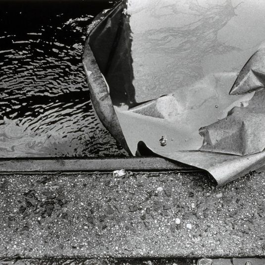 Untitled (Water, paper, curb), from the series Manholes