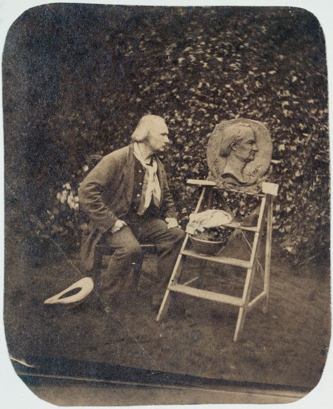 Victor Hugo dans le jardin de Hauteville House devant son médaillon sculpté par Victor Vilain