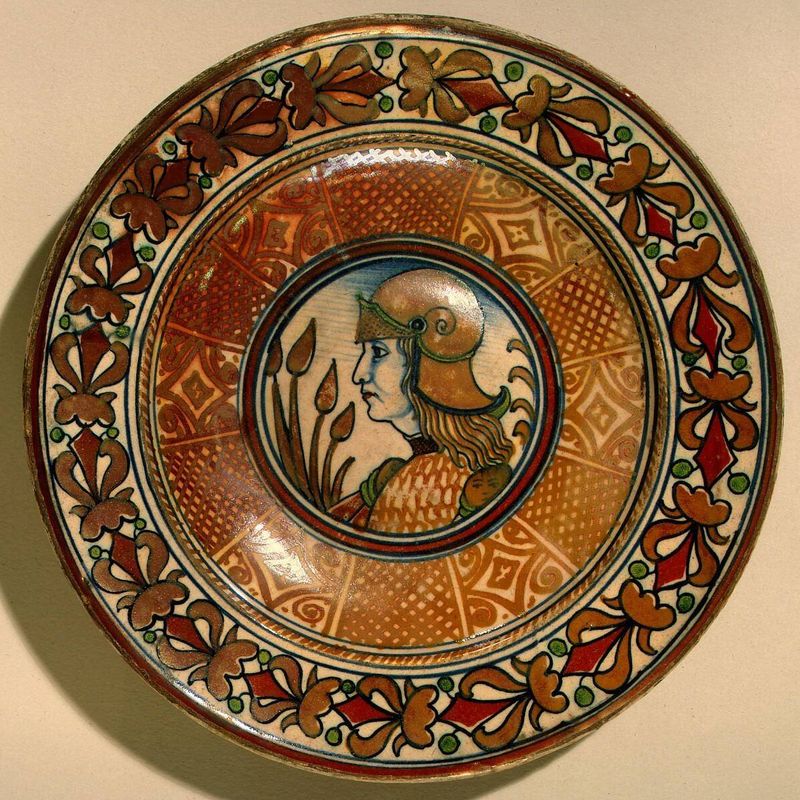 Plate with running plant border and geometric panels on well; in the center, profile bust of a man in armor