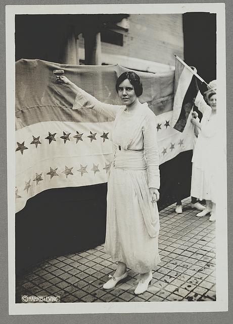 Alice Paul Raises a Glass in front of the Ratification  Banner,  August  26,  1920