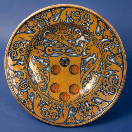 Large dish with plant-pattern border; in the center, the arms of a Medici pope