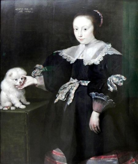 Portrait of an eleven year old girl with a dog, dressed in Spanish fashion